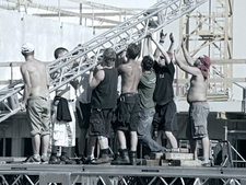 9 Bühnentechniker arbeiten in der Sonne auf einer Bühne