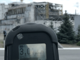 Handheld measuring device used to determine the ambient dose rate in front of the Chernobyl reactor. The display shows a value of 3.04 microsievert per hour.