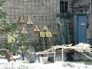 Warning signs in the sun in front of a workshop (show image)