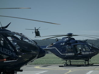 Two landed helicopters and a helicopter in the air. (choosen image)