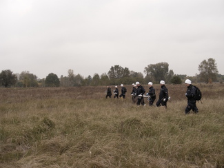 The group paces the field off with measuring instruments  (choosen image)