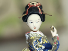 Geisha-Puppe in traditionell japanischem Gewand mit porzellanweißer Haut