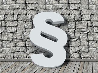 Paragraphenzeichen vor einer Mauer Paragraphenzeichen vor einer Mauer