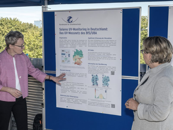 Dr. Michaela Kreuzer vom BfS und Bundesumweltministerin Svenja Schulze vor einem Plakat zum UV-Messnetz