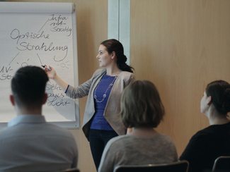 Eine Frau erklärt am Flipchart neue Entwicklungen